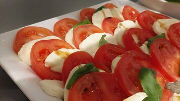 Ein Teller Caprese-Salat mit Tomaten, Mozzarella und Basilikum.