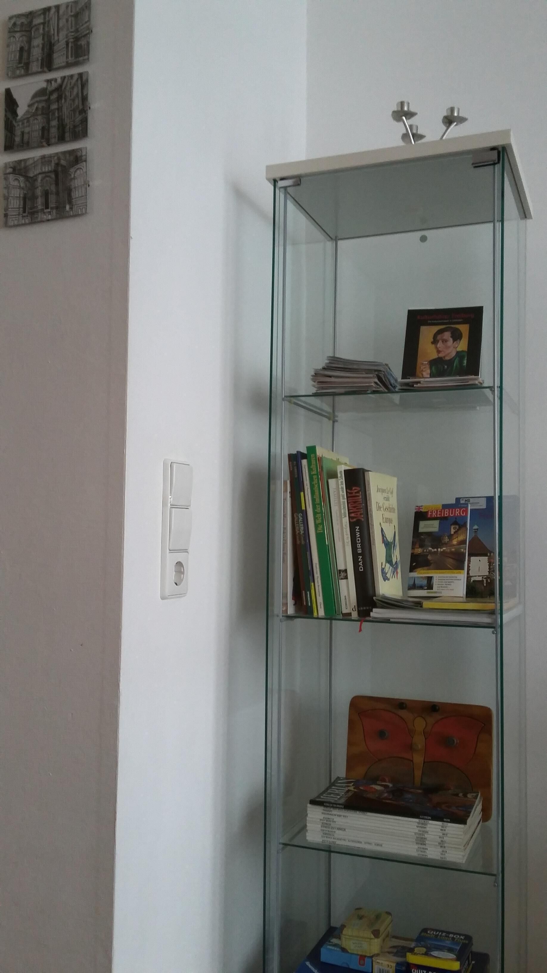 A glass display cabinet with books and a board game.
