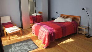 Ein Schlafzimmer mit Bett, Stuhl, Kleiderschrank und Nachttisch.