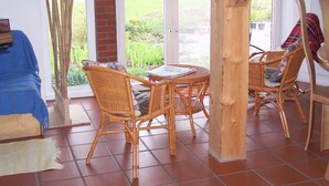 A covered patio with wicker furniture, a brick wall, and a glass door leading to a garden. - 305WHAYA: 3  BR, 2  BA House in Tampa, Sleeps 6 (Butjadingen)