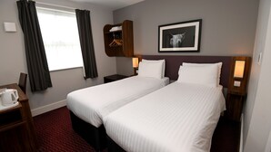 A hotel room with two beds, a wardrobe, a desk with a kettle, and a framed picture on the wall. - Pine Marten, Dunbar by Marston's Inns (Dunbar)