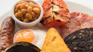 A plate with various foods including sausages, beans, a grilled tomato, a fried egg, mushrooms, and a slice of bread. - Pine Marten, Dunbar by Marston's Inns (Dunbar)