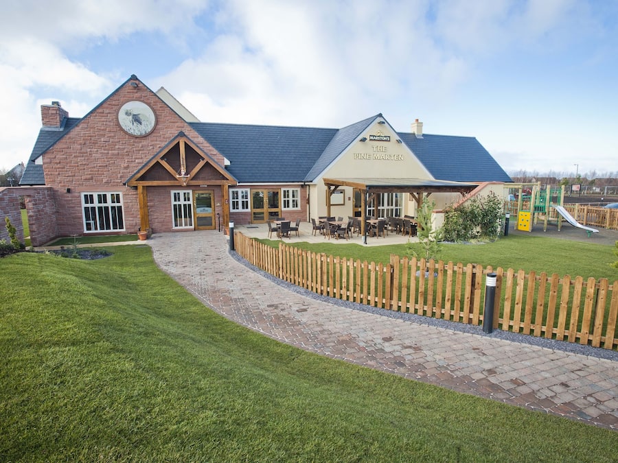 A building with a brick facade, a covered patio area, and a playground.