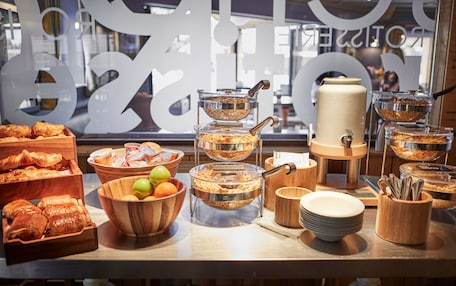 A buffet setup with various food items and serving utensils.