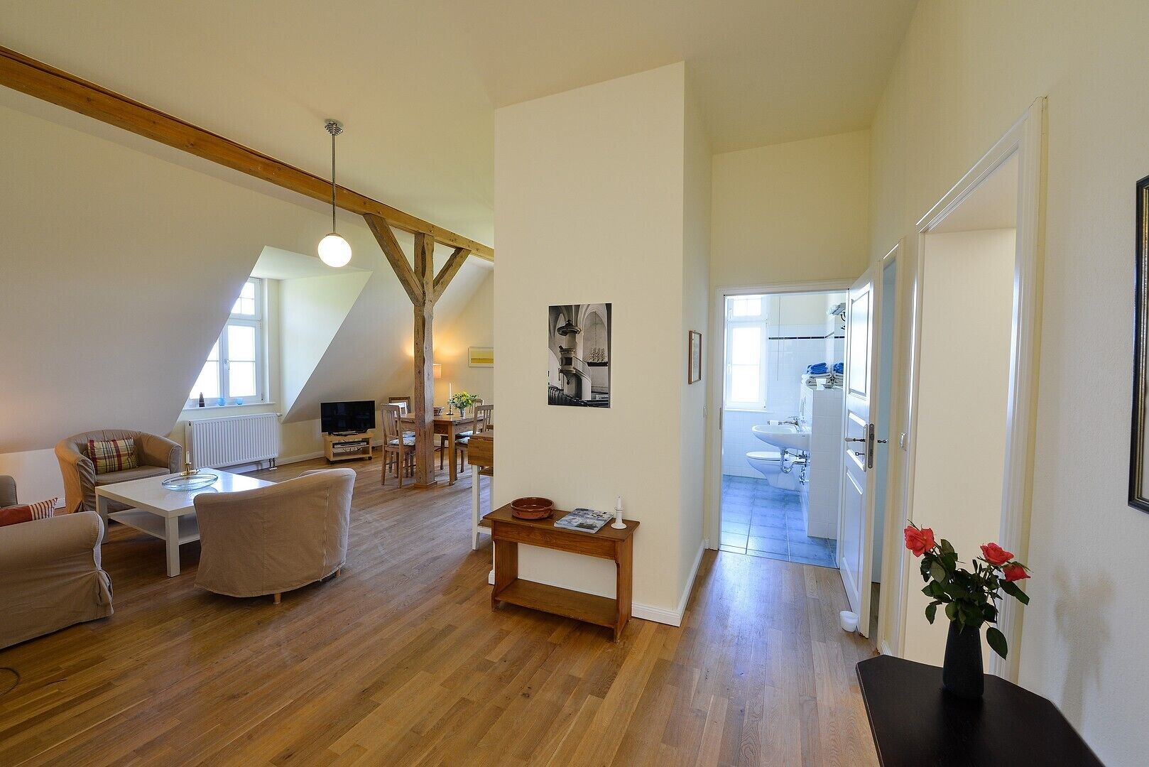 Ein großzügiges Loft mit hohen Decken, Holzbalken, Essbereich, Wohnbereich und Küche.