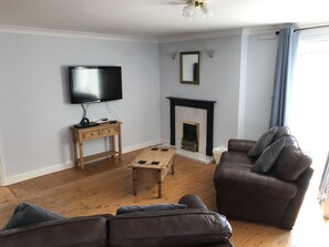 Apartamento família, vista para a montanha | Área de estar | TV de tela plana