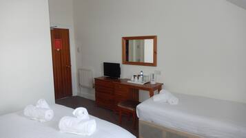 A hotel room with two beds, a wooden desk, a television, and a mirror.