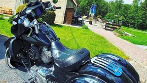 A motorcycle parked in front of a building with a sign that reads 'Esterblitz Hotel & Restaurant.'