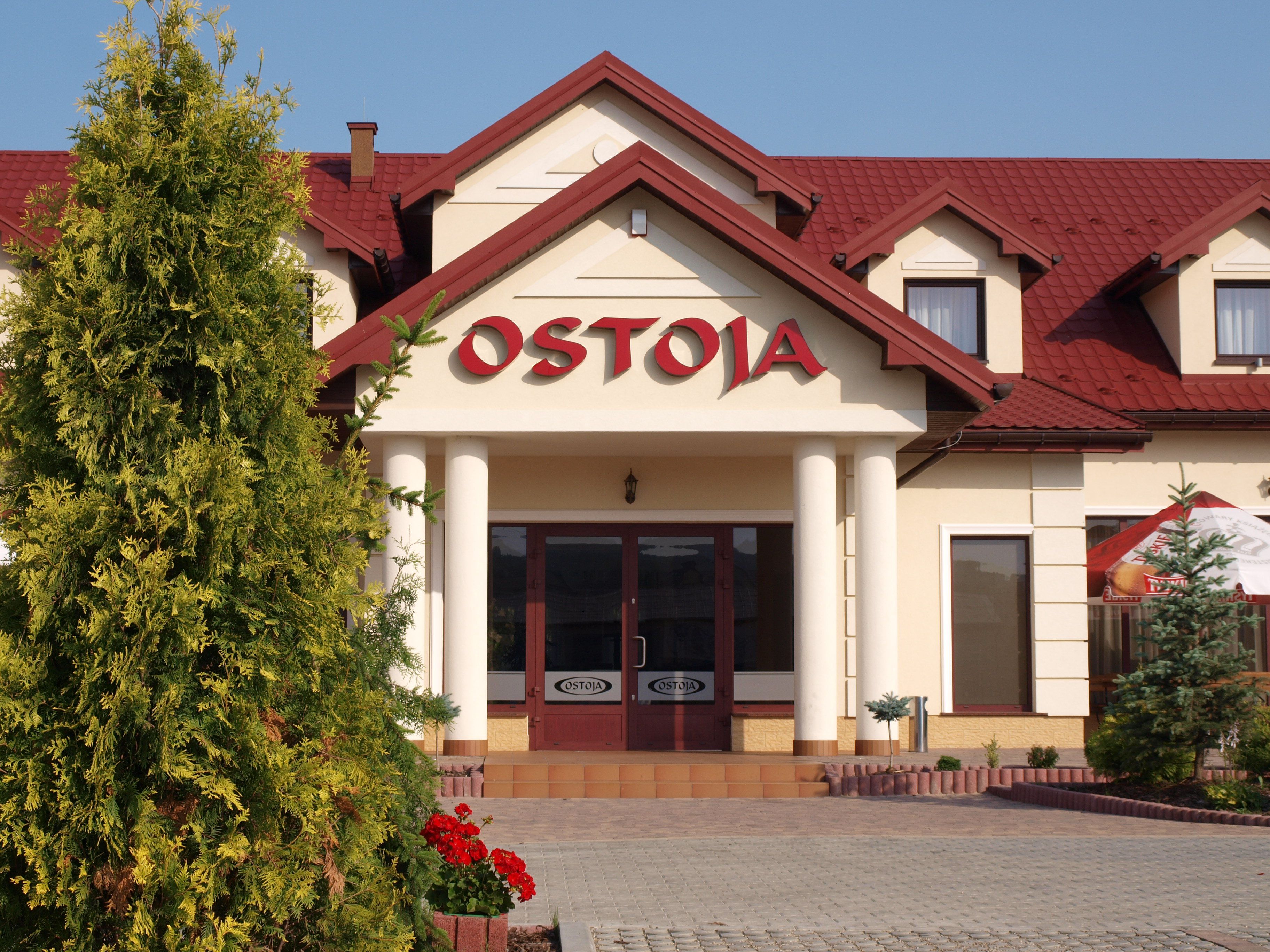 Un edificio con un letrero que dice "OSTOJA" en la entrada.