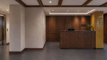 Un comptoir d’accueil avec un revêtement en bois, un espace d’accueil doté d’un mur carrelé et un plafond avec des poutres en bois.