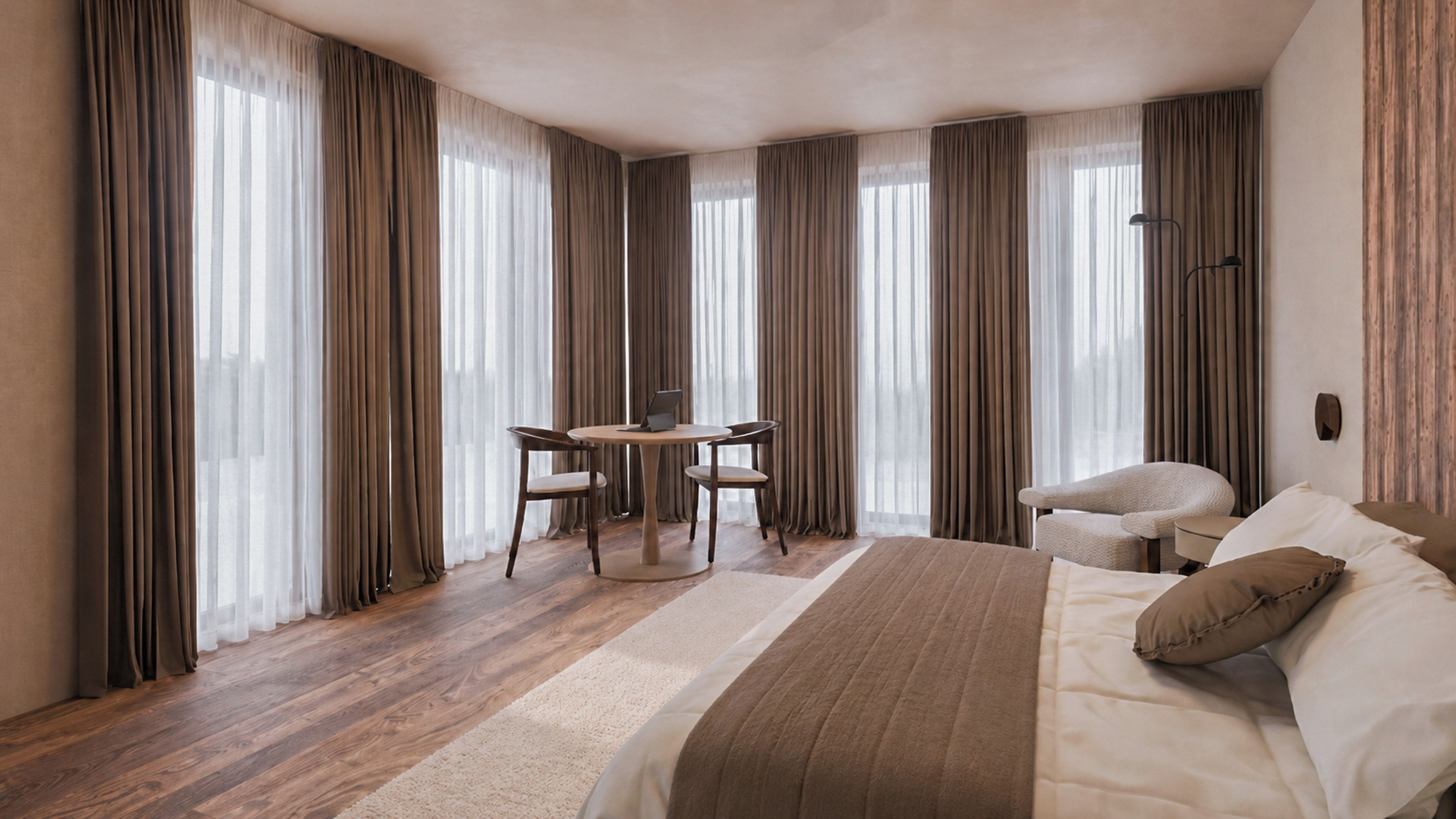 A hotel room with a bed, a desk with a chair, and a sofa.