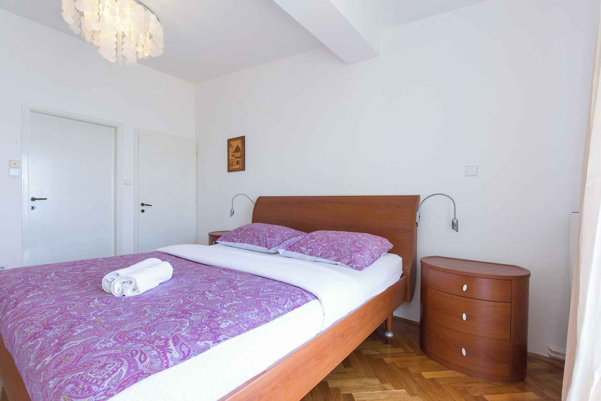 Camera da letto con un letto di legno, un comodino e una porta bianca.