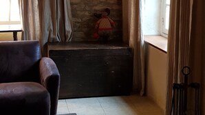 A cozy room with a stone wall, a painting, a plush toy, and a window with curtains. - Charming renovated farmhouse in Burgundy, near Vezelay. (Chamoux)