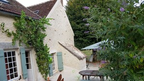 A rustic building with a thatched roof, a wooden table, and a bench. - Charming renovated farmhouse in Burgundy, near Vezelay. (Chamoux)
