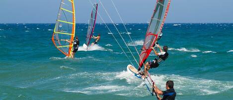 A group of windsurfers on a clear day.