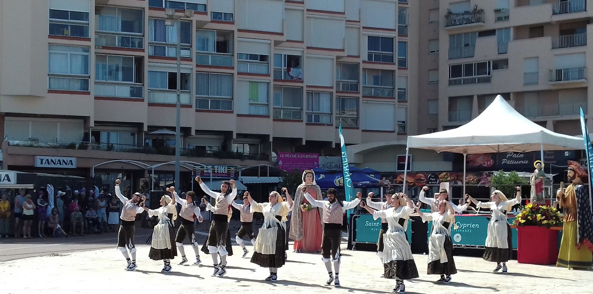 A group performing on a public square with buildings in the background.