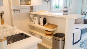 A modern kitchen with a built-in stove, a coffee maker, and a trash bin. - Homerez - Sea View Studio - Collioure (Collioure)