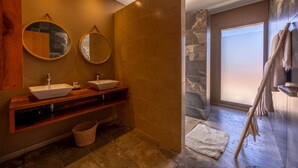 A modern bathroom with two sinks, a wooden vanity, a stone accent wall, and a large window. - To complete (Marrakech)