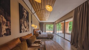 Ein modernes Schlafzimmer mit einem großen Bett, einer Couch und einem Holztisch.