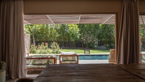 A room with a large window overlooking a swimming pool and garden. - To complete (Marrakech)