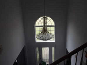 A staircase with a view of a large arched window and a chandelier. - Peaceful Country Estate<br>Home is equipped with lock box late or early arrival (Hope Hull)
