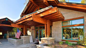 Un chalet avec une façade en bois, des fondations en pierre et de grandes fenêtres.