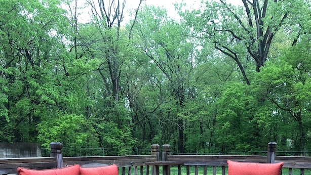 A deck with two red cushioned chairs and a glass table. - The Bunkhouse  318 E. Main St. Warsaw, Mo. (Warsaw)