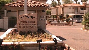 Un panneau indiquant l'emplacement du complexe de condominiums Pointe Resort, situé à Tapatio Cliffs, et présentant un espace paysager agrémenté de plantes et d'une fontaine.