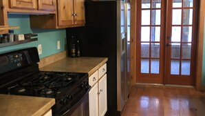 A kitchen with wooden cabinets, a black refrigerator, and a stove. - Quiet and peaceful cottage in Crosslake (Crosslake)