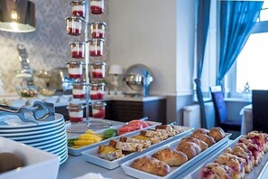A buffet with various food items and a dessert tower.