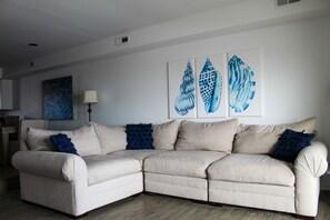 Relax in this stylish living room with a beige sofa, throw pillows, and a floor lamp.
