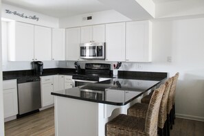 Enjoy cooking in this kitchen with an oven, stainless steel microwave, and a small island.