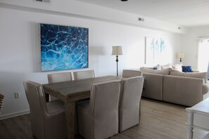 Relax in a stylish living space with a dining area, sofa, and abstract art.