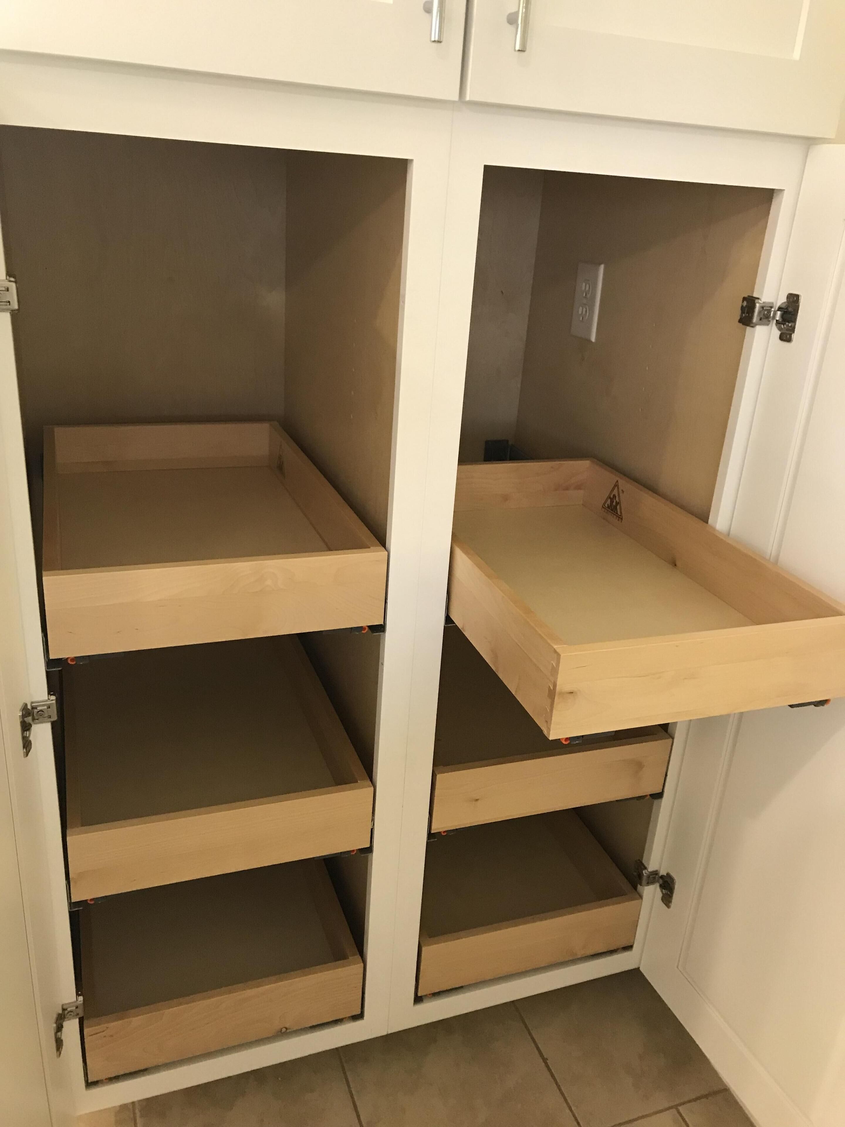 Un meuble blanc doté de plusieurs étagères ouvertes et de tiroirs.