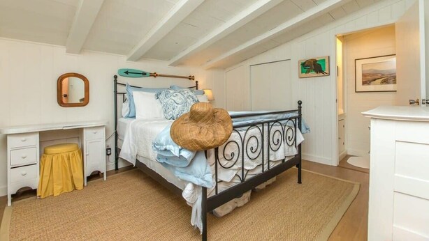 A bedroom with a bed, bedside table, and a mirror.