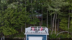 A docked boat house with a covered deck and a garage.