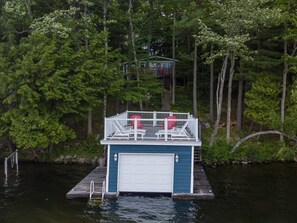 Ein Bootsanleger mit überdachter Terrasse und einer Garage.