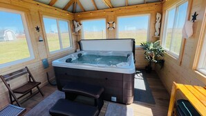 A wooden cabin with a hot tub, wooden benches, and large windows. - Rest Ashored in Anne's land!- Hot tub, Kayaks Centrally located, stunning views. (Kensington)