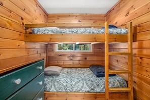 A bunk bed room with a window, wooden walls, and a green dresser. - Perfect Lakefront Family Cabin, 2 Kayaks Included! (Interlochen)