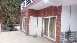 A two-story building with a brick facade, white doors, and large windows.