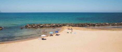 Rannalla, aurinkotuoleja, rantapyyhkeitä