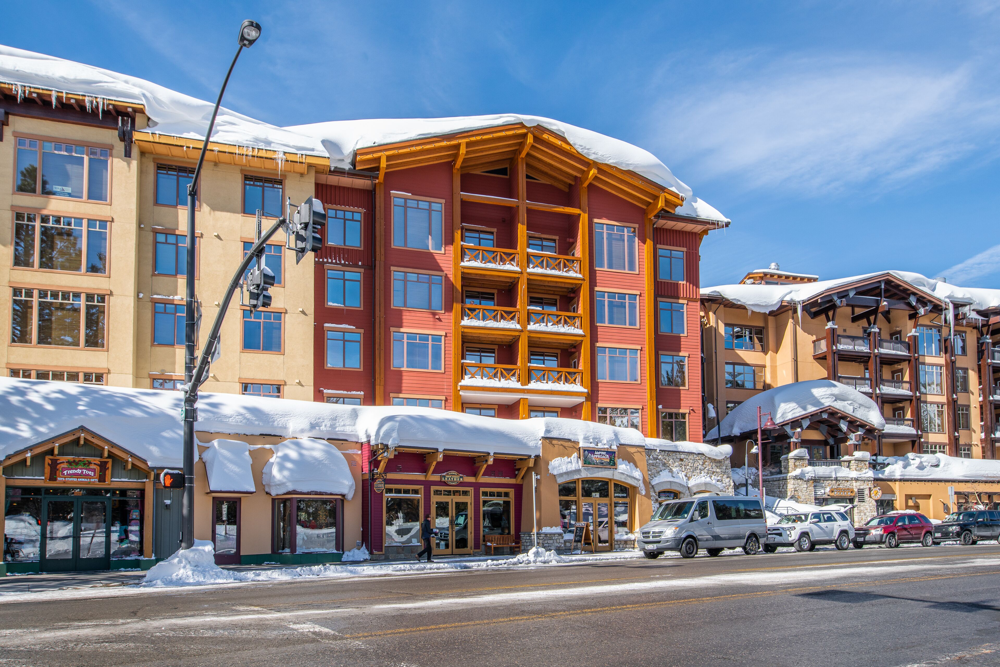 Un hôtel à plusieurs étages, doté de balcons, avec une station de ski en arrière-plan.