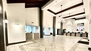 A spacious lobby with a herringbone patterned floor, large pillars, and a reception desk area. - Shores of Panama 2BR Unit 1911! 19th Floor Gulf Views! Luxury Furnishings! (Panama City Beach)