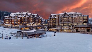 A large, multi-story lodge with a ski lift in the foreground, surrounded by snow. - Luxury Ski-in/Ski-out residence (Breckenridge)