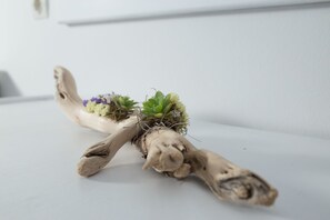 A plant with green leaves and purple flowers in a white pot. - Akti Hotel & Apartments (Lesvos)