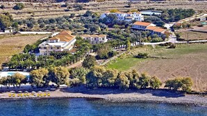 Una propiedad costera con varias villas, piscina y zona de playa.