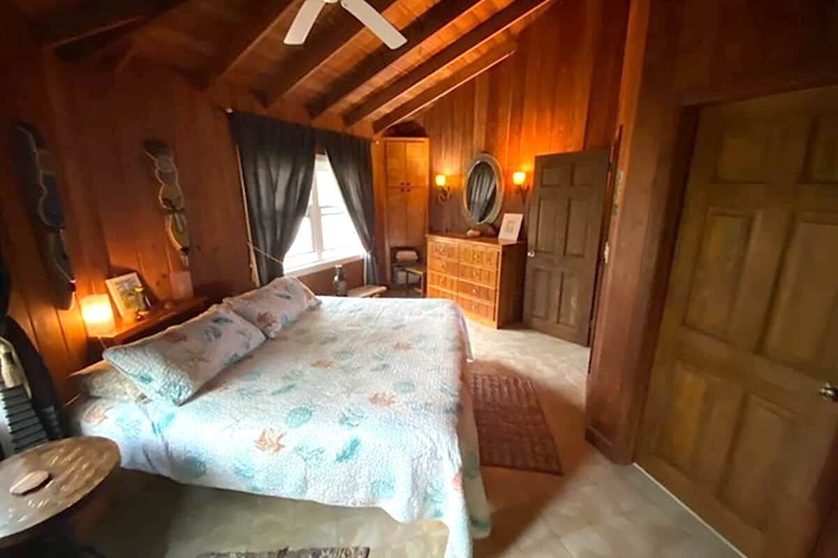 A cozy bedroom with a bed, dresser, and a mirror.