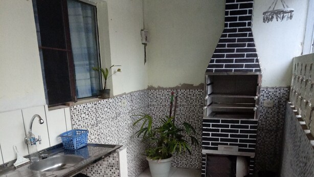 A compact kitchen with a built-in stove, a sink, and a window. - Beachfront house in Bertioga, 50 meters or 2 minutes from Indaiá Beach. (Bertioga)
