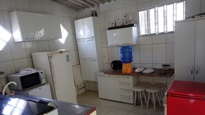 A kitchen with white cabinets, a red refrigerator, a microwave, a sink, and a window. - Beachfront house in Bertioga, 50 meters or 2 minutes from Indaiá Beach. (Bertioga)