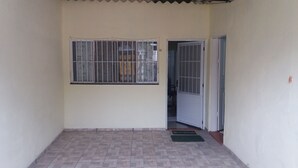 A small, enclosed balcony with a tiled floor and a barred window. - Beachfront house in Bertioga, 50 meters or 2 minutes from Indaiá Beach. (Bertioga)